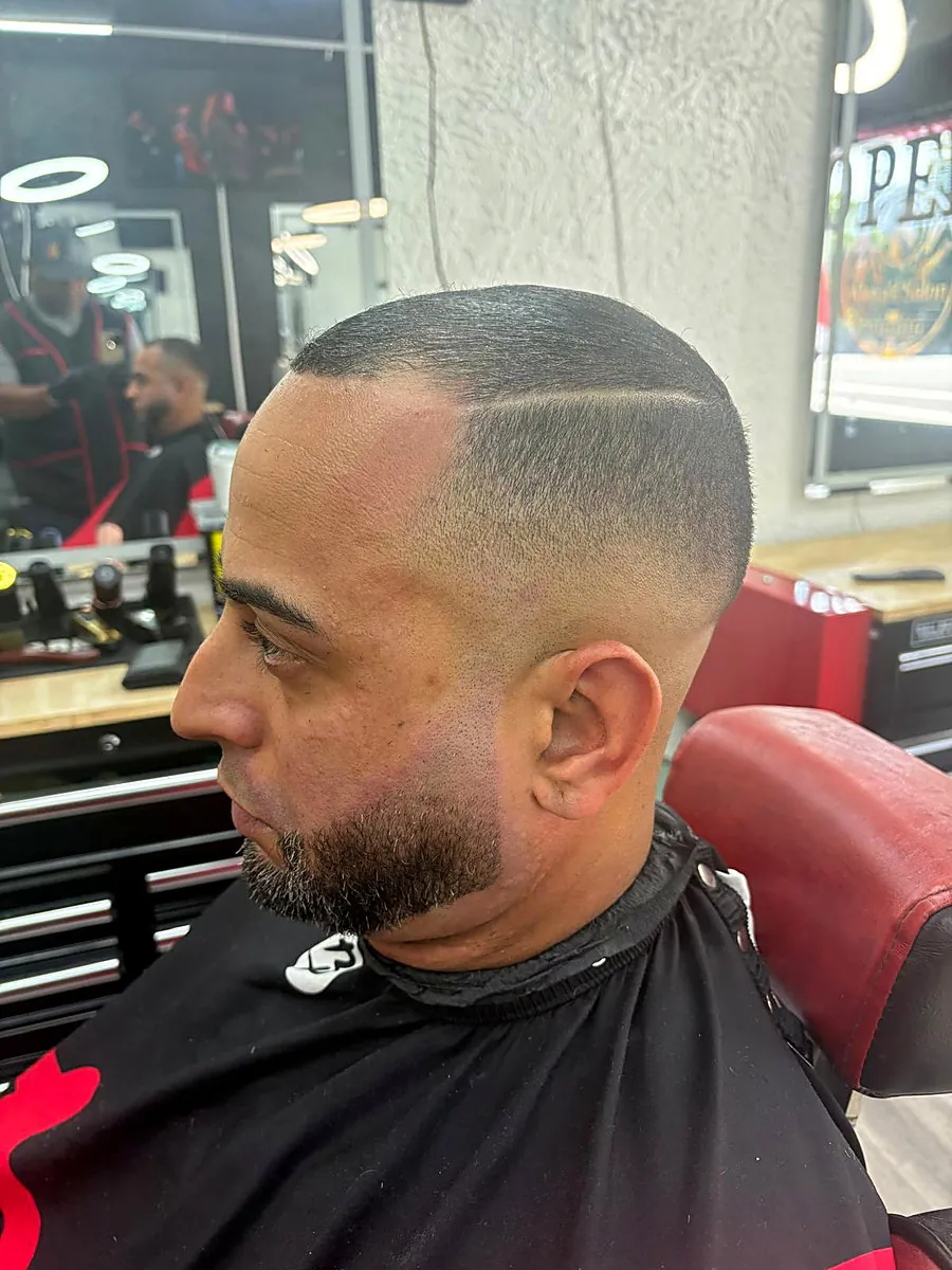 Skin fade with hard part and beard